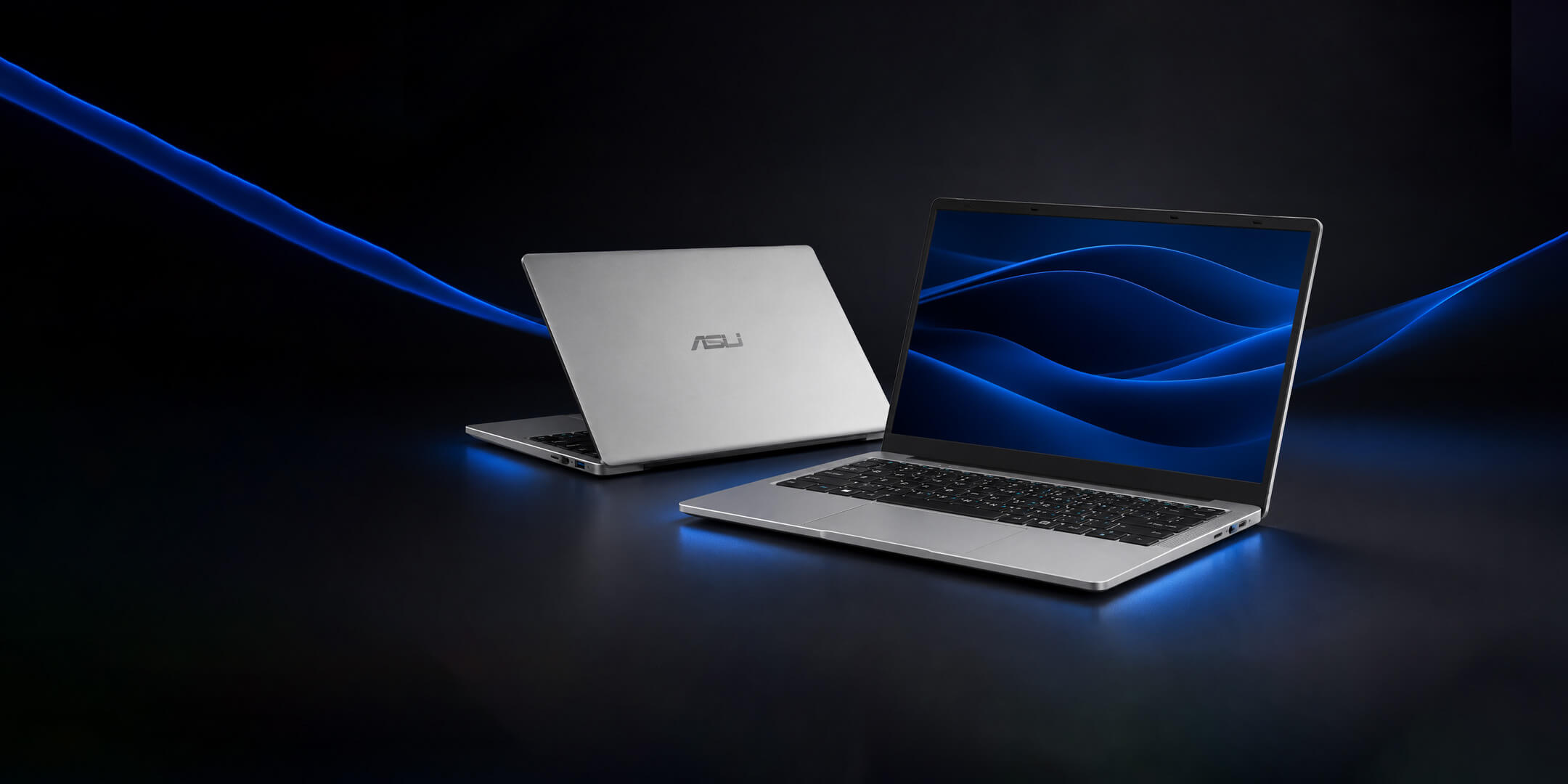 Two silver ASIJ P02 laptops displayed against a blue background